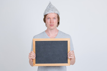 Young man with tin foil hat holding blackboard