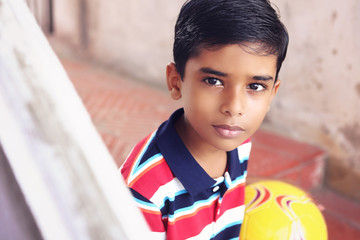 Portrait of Indian little boy holding the football