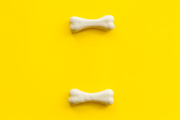 Obraz premium Treats for dogs. Chewing bones on yellow background top view copy space