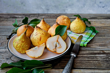 Fresh organic farmer pear juice in a glass with raw whole sliced pears .
