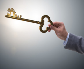 Businessman holding key in real estate concept