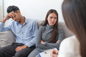 Asian couple have problems sitting on so sofa their getting advice and consult from woman...