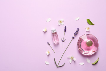 Flat lay composition with elegant perfume on lilac background, space for text