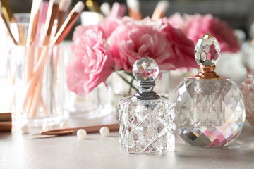 Different perfume bottles on dressing table, space for text