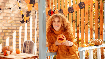 Young adult mother and daughter looking at carved pumpkin with smoke