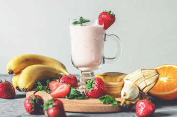 banana, strawberry and orange smoothies with mint on the table, front view