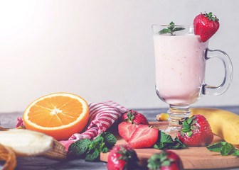 banana, strawberry and orange smoothies with mint on the table, front view