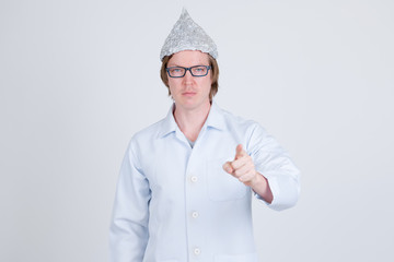 Young man doctor with tinfoil hat pointing at camera