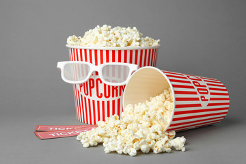 Popcorn, cinema tickets and 3d glasses on grey background