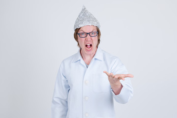 Stressed young man doctor with tinfoil hat looking angry