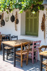 Front view of small cafe exterior. Table and empty chairs outdoor near the white wall. Tourist places. Typical Mediterranean restaurant, a place holidays in the summer