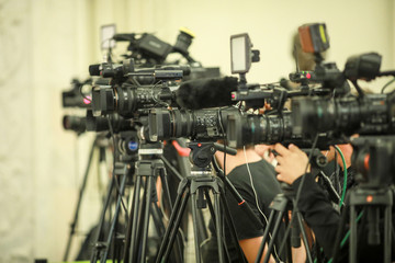 Shallow depth of field image with television video cameras and recording equipment during a press event