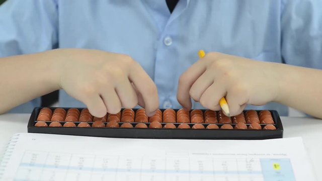 child hand over math problem counting abacus