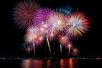 Amazing beautiful colorful fireworks display on celebration night, showing on the sea beach with...