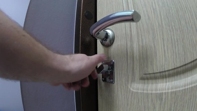 man hand closed a metallic Lock at home