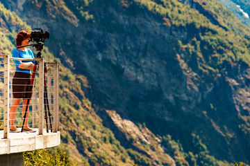 Tourist with camera on tripod in Norway nature