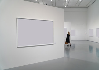 exhibition room of the gallery with blank pictures and people