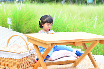 Little Child Girl Drinking Water on The Table with Grass Flower