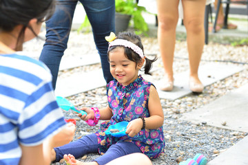 Little Child Girl with Mom Playing Sand and Stone