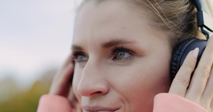 Handheld view of woman listening to music by headphones