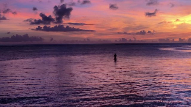 Graphic Purple Sunset with Silhouette of lonely fisherman in riviera. Chatan, Okinawa, Japan.