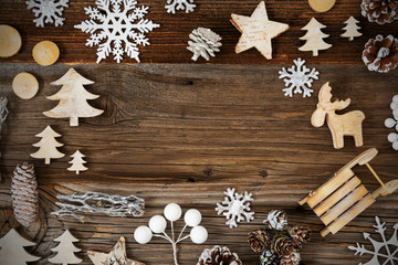Frame Of Christmas Decoration Like Sled, Tree, Star, Fir Cone And Snowflakes. Brown Wooden Background With Copy Space