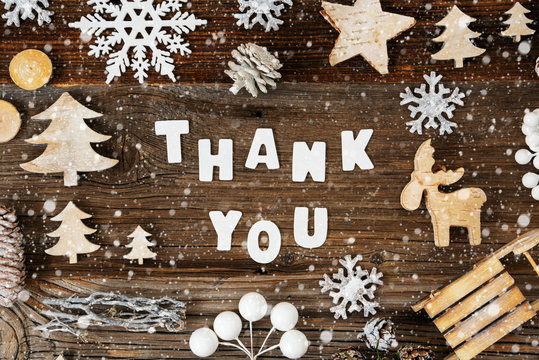 White Letters Building The Word Thank You. Wooden Christmas Decoration Like Sled, Tree, Snowflakes And Star. Brown Wooden Background