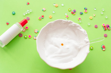 a girl making slime herself. child making slime on green background. 