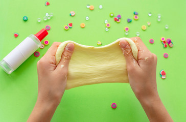 a girl making slime herself. child making slime on green background. 