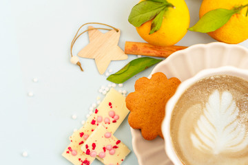 cozy winter coffee break - cappuccino, ginger cookies, chocolate, cinnamon, tangerines