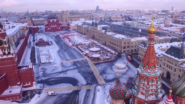 Unique aerial flight Red square Moscow capital Russia. Winter snow holidays New Year celebration preparation. Cathedral orthodox colorful church. Happy people walk. Day dramatic mood
