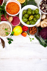 Healthy food selection, clean eating. Fruit, vegetable, seeds, superfood, cereals, leaf vegetable on white background, copy space, top view..