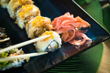 Sushi Set. Various rolls on a wooden plate. On dark rustic background