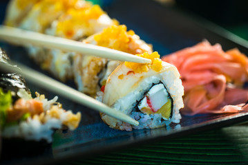 Sushi Set. Various rolls on a wooden plate. On dark rustic background