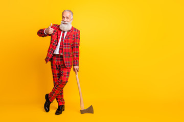 Full length body size view of his he nice handsome attractive cheerful cheery glad gray-haired man carrying ax showing thumbup isolated over bright vivid shine vibrant yellow color background