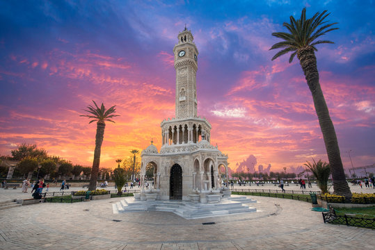 Konak Square street view with old clock tower (Saat Kulesi) at sunset. It was built in 1901 and accepted as the official symbol of Izmir City, Turkey. 