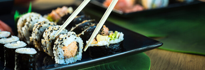Sushi Set. Various rolls on a wooden plate. On dark rustic background © Aerial Mike