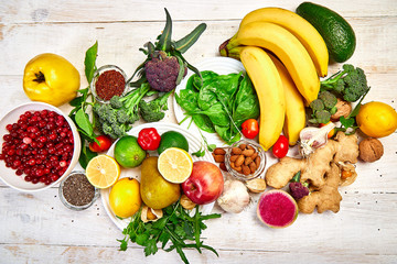 Selection of food rich in antioxidants and vitamins and mineral  sources, vegan food  on white wooden background. Healthy balanced dieting concept, ingredients for cooking. Top view.