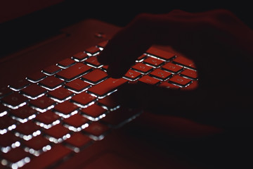 man typing on a computer at night. night work concept.