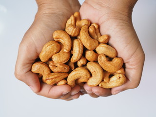 Above of hand with cashew nuts. isolated on white background.