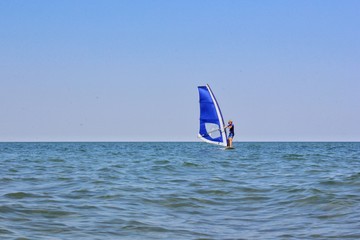 Man windsurfer with sea and sky background 
