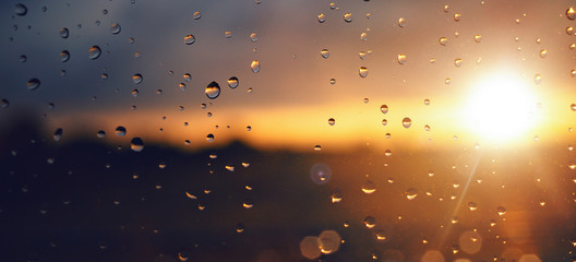 Raindrops on a windowpane at sunset panorama