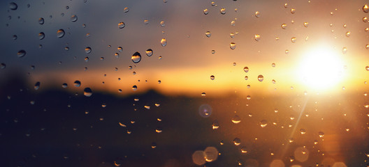 Raindrops on a windowpane at sunset panorama © photoschmidt