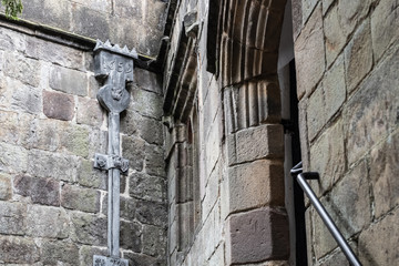 Detailed view of medieval leaded guttering seen on the outside of a medieval building. The date made can be seen on the gutter and royal crests further down.