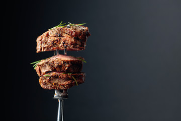 Fototapeta Grilled ribeye beef steak with rosemary on a black background. obraz