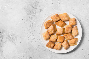 Cottage cheese cookies on a round ceramic plate on a light gray background. The view from the top