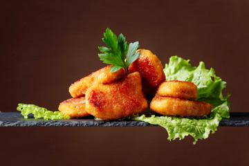  Fried chicken nuggets with parsley and salad.
