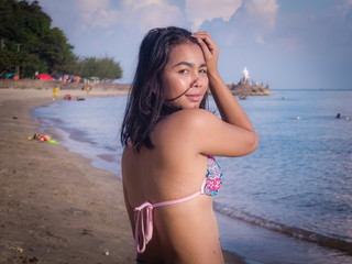 Asian Female with Wearing Bikini Stands on Tropical Beach at Sunset (Variation Looking at Camera)