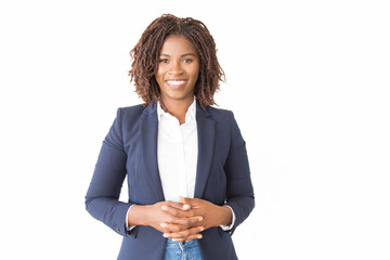 Happy cheerful female consultant looking at camera. Young African American business woman with clasped hands standing isolated over white background, smiling. Happy entrepreneur concept - Powered by Adobe