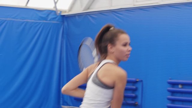 Female tennis player doing lob during match and feeling high because of result